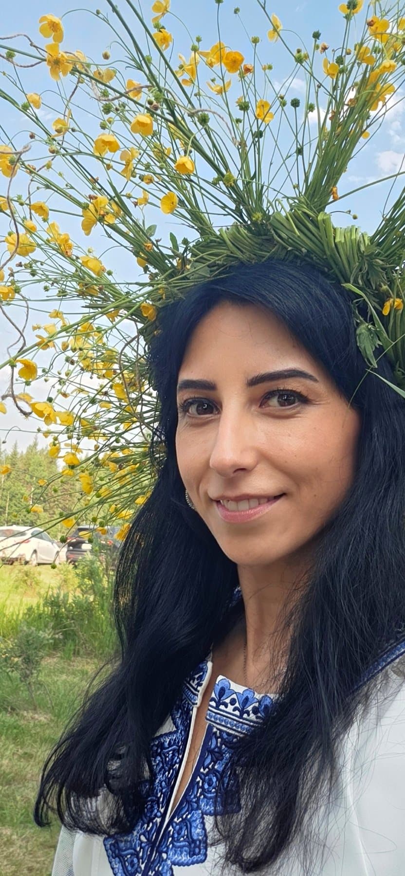 Close portrait of Olha Vozna wearing a crown of yellow wildflowers at Kupala Fest 2026