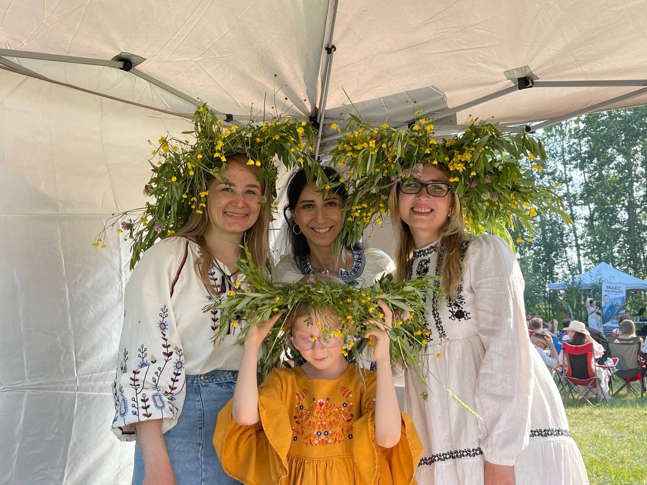 Olha Vozna with festival guests and a child wearing flower crowns